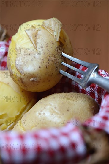 Boiled potatoes with fork in basket