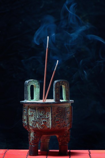 Incense burner with burning incense sticks