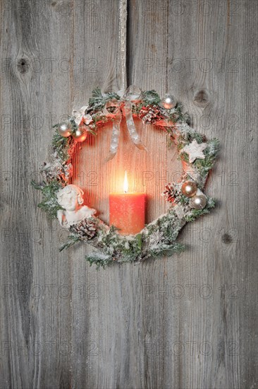 Christmas wreath on wooden wall with candle