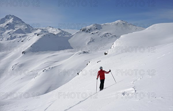 Skier looking at snowy terrain
