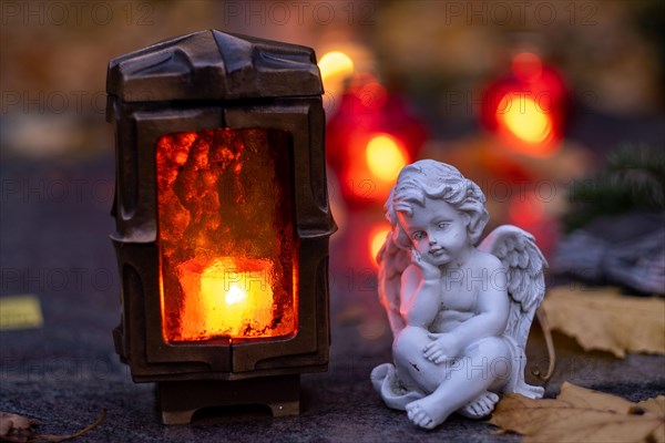 Burning grave light and angel figure on a grave