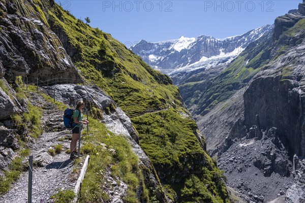 Young woman on hiking trail from Grindelwald to Schreckhornhuette