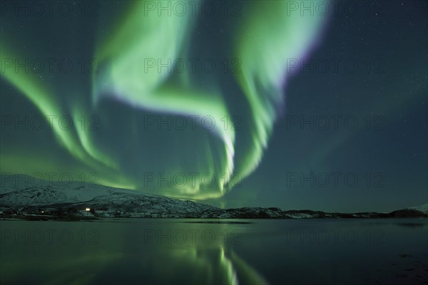 Aurora borealis with water reflection in fjord