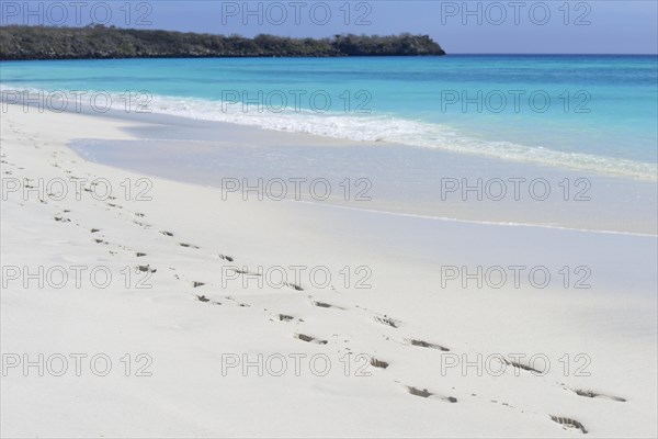 Footprints on white sand beach