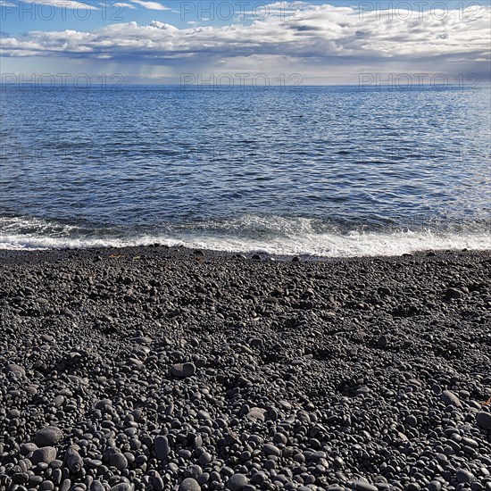 Black stones rounded by the sea