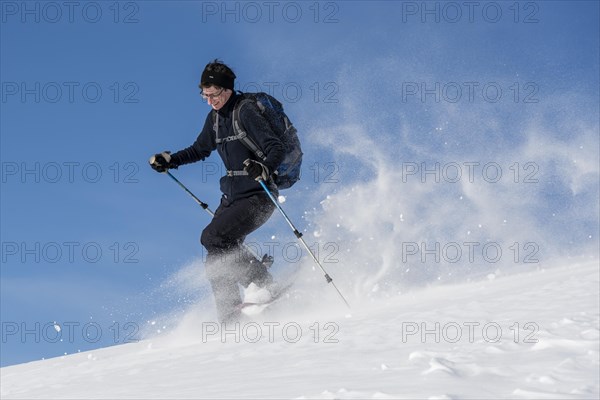 Woman with snowshoes walking through snow