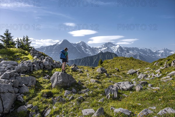 Hiker standing on rocks and looking at mountains