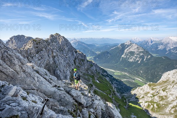 Mountaineer climbs on a secured fixed rope route