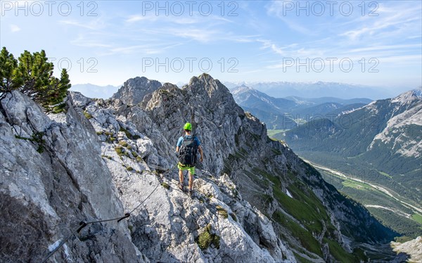 Mountaineer climbs on a secured fixed rope route