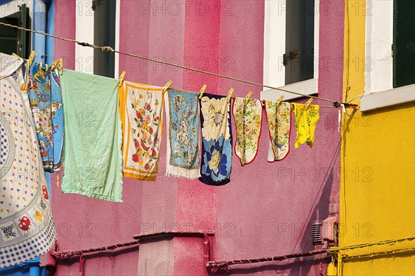 Towels drying on line in front of colorful houses