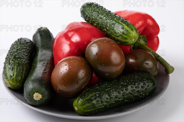 Fresh garden vegetables with water drops on a plate