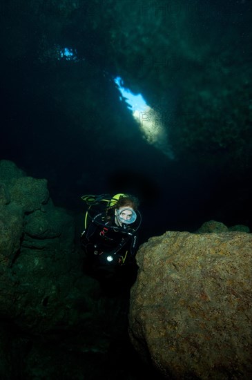Diver in cave Cueva Luz near Cala Ratjada