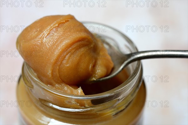 Salted caramel cream on spoon with glass