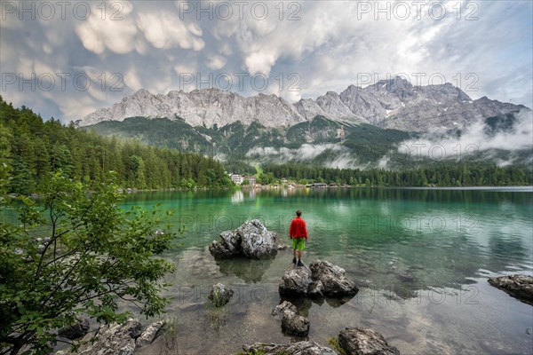 Young man standing on a rock on the shore