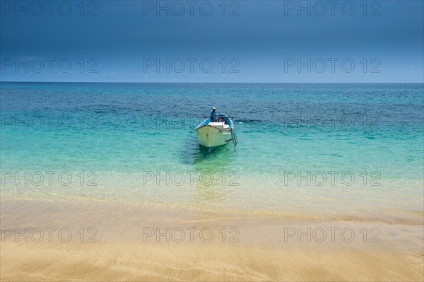 Little motorboat in the turquoise waters of Banana beach
