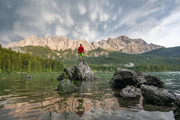 Young man standing on a rock on the shore