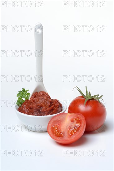 Tomato paste with spoon in bowl