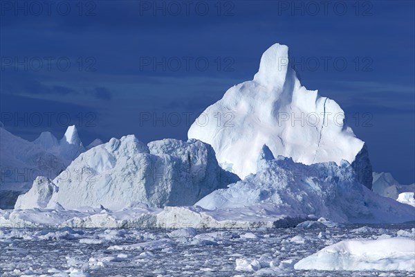 Massive icebergs floating in the Arctic sea in the Disko Bay