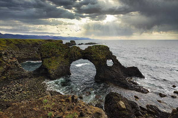 Eroded cliff at the Atlantic Ocean with Gatklettur and dramatic cloud formation