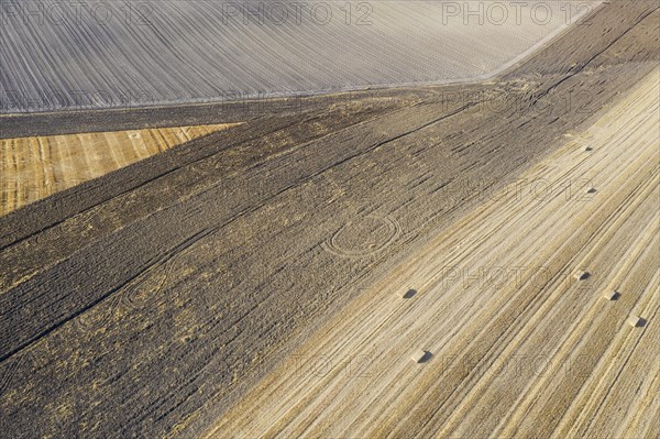 Bales of straw and abstract patterns in cornfield after wheat harvest