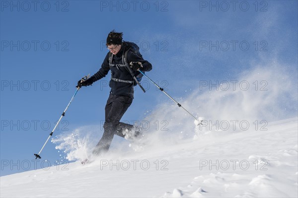 Woman with snowshoes walking through snow