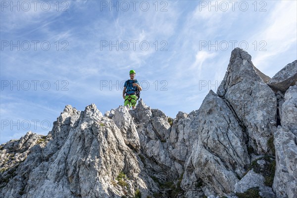 Mountaineer climbs a secured via ferrata