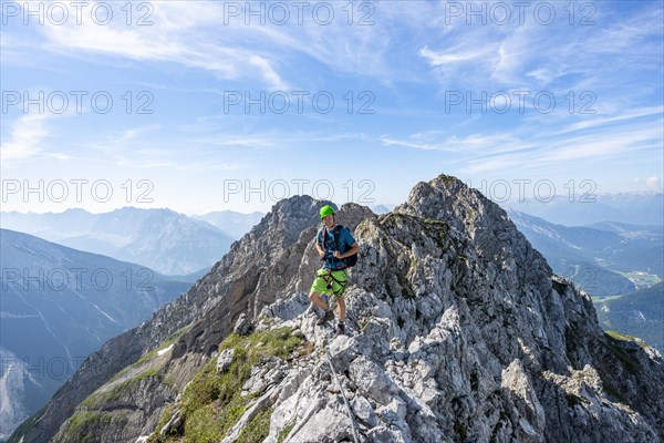 Mountaineer on a ridge on a secured fixed rope route