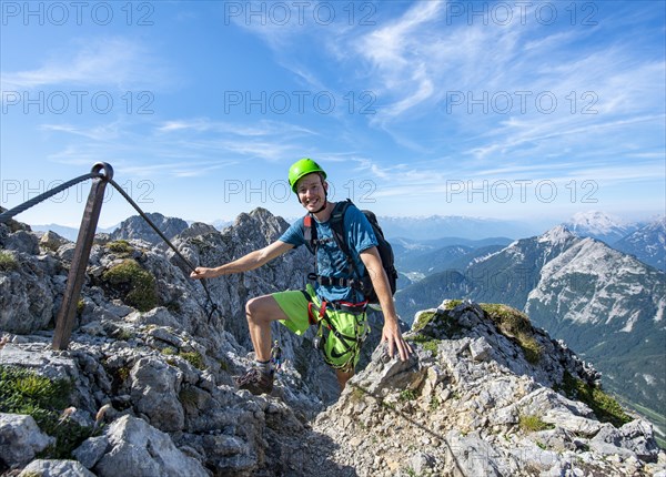 Mountaineer climbs a secured via ferrata