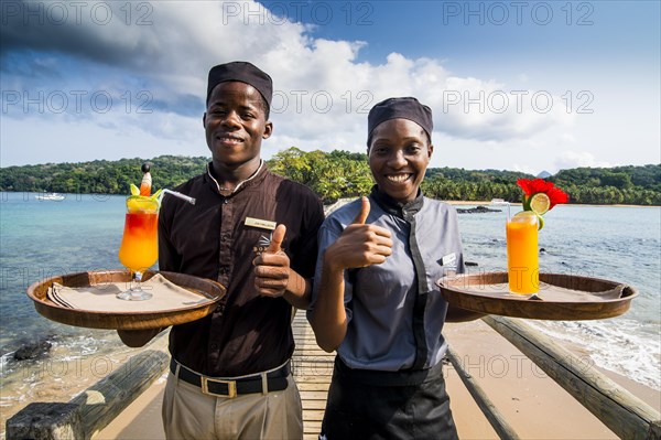 Waiters serving cocktails on a long wooden pier in the Bom Bom Resort