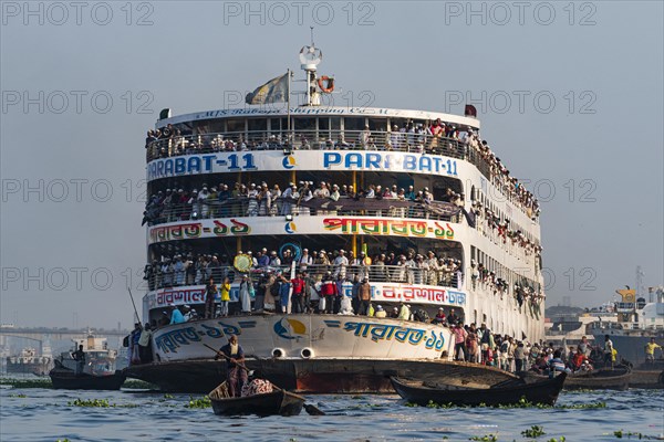 Overloaded passenger ferry with pilgrims on the Dhaka river