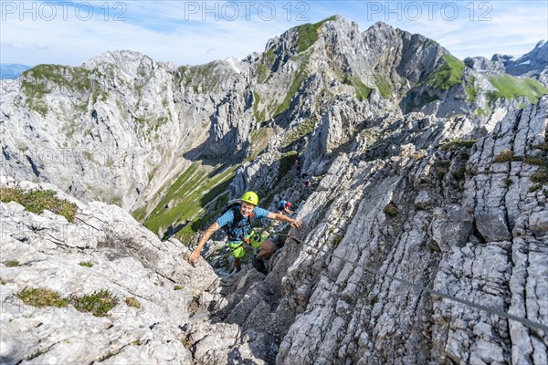 Mountaineer climbs a secured via ferrata