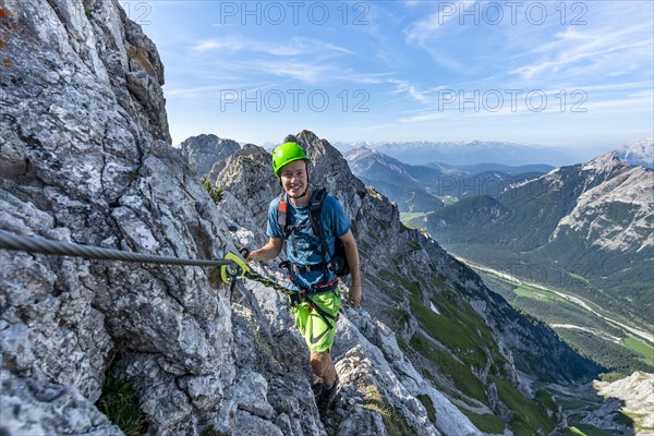 Mountaineer climbs on a secured fixed rope route