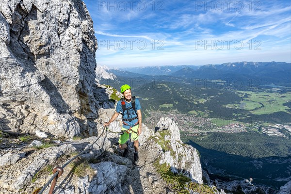 Mountaineer climbs on a secured fixed rope route