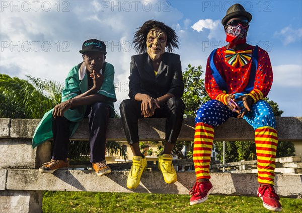 Boys in costums sitting on a wall