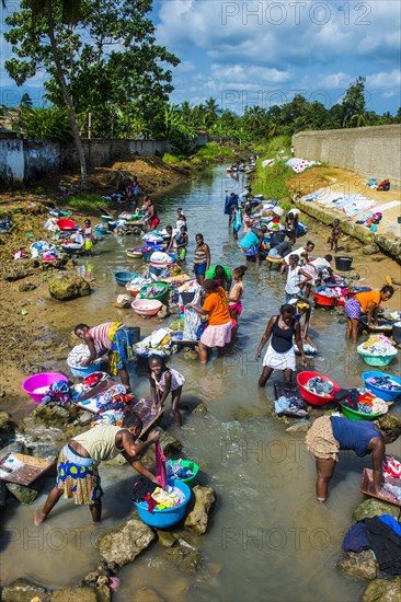 Women washing clothes in a river bed