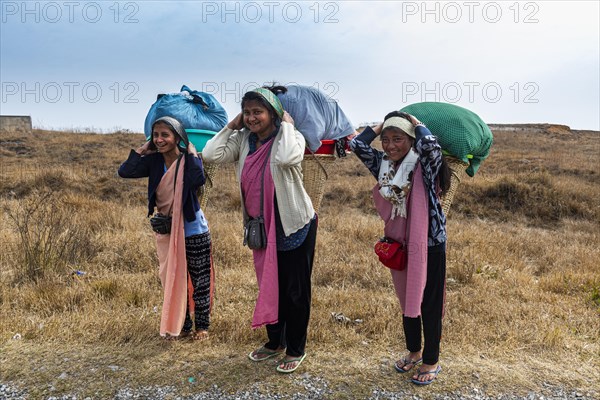 Khasi women carrying the laundry to a creek in a traditional basket