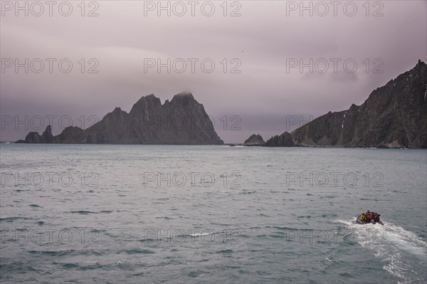 Zodiac with divers on its way to the rugged shore of Elephant island