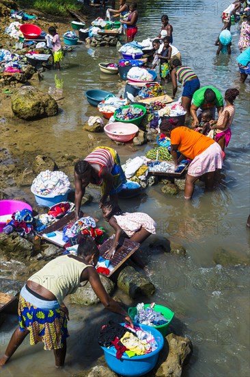 Women washing clothes in a river bed