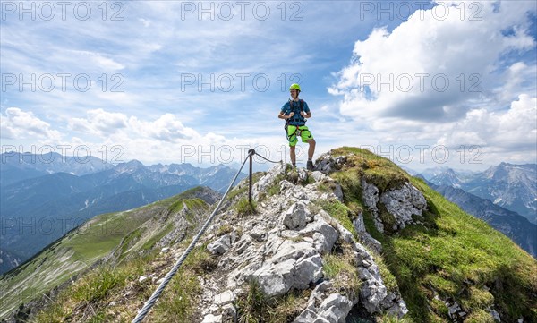 Mountaineer on a ridge on a secured fixed rope route