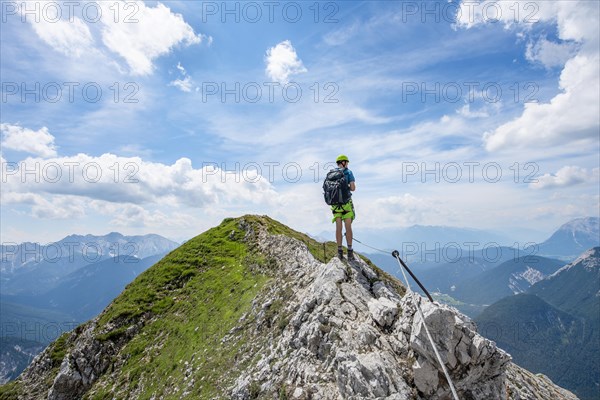 Mountaineer on a ridge on a secured fixed rope route