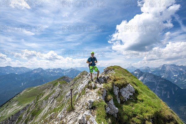 Mountaineer on a ridge on a secured fixed rope route