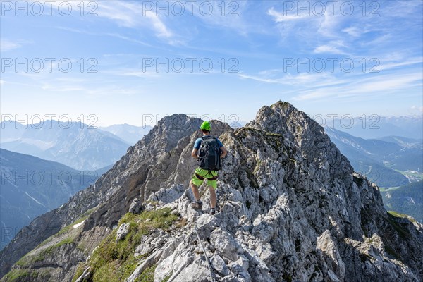 Mountaineer on a ridge on a secured fixed rope route