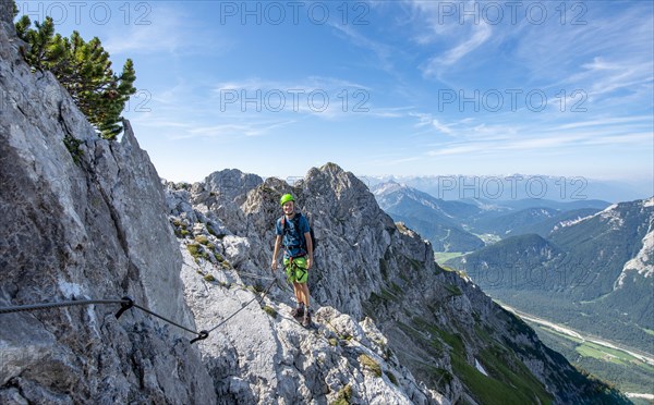 Mountaineer climbs on a secured fixed rope route