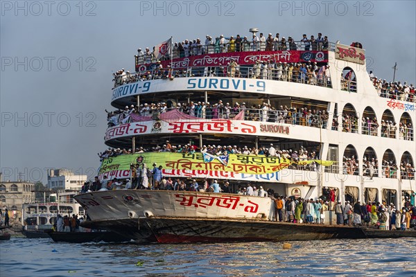 Overloaded passenger ferry with pilgrims on the Dhaka river