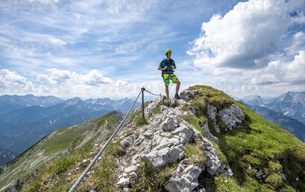 Mountaineer on a ridge on a secured fixed rope route