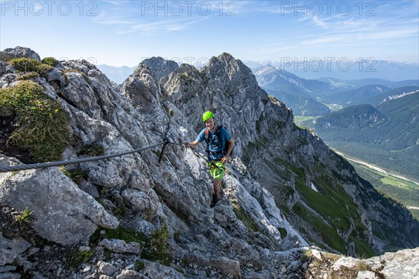 Mountaineer climbs on a secured fixed rope route