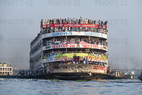 Overloaded passenger ferry with pilgrims on the Dhaka river