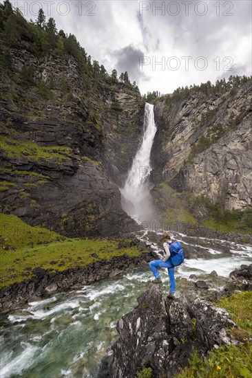 Hiker standing on rocks by river Driva