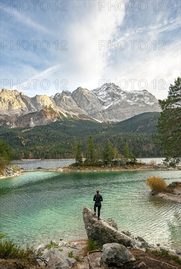 Young woman standing on a rock on the shore