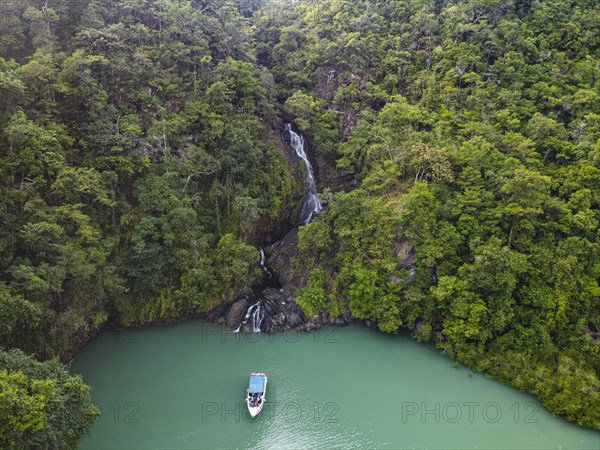 Aerial of a waterfall dropping right in the ocean on Dome island